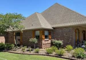 brick home with wooden shudders