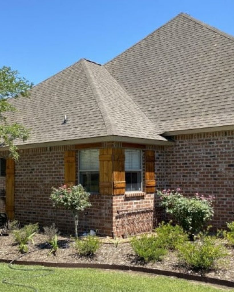 brick home with wooden shudders